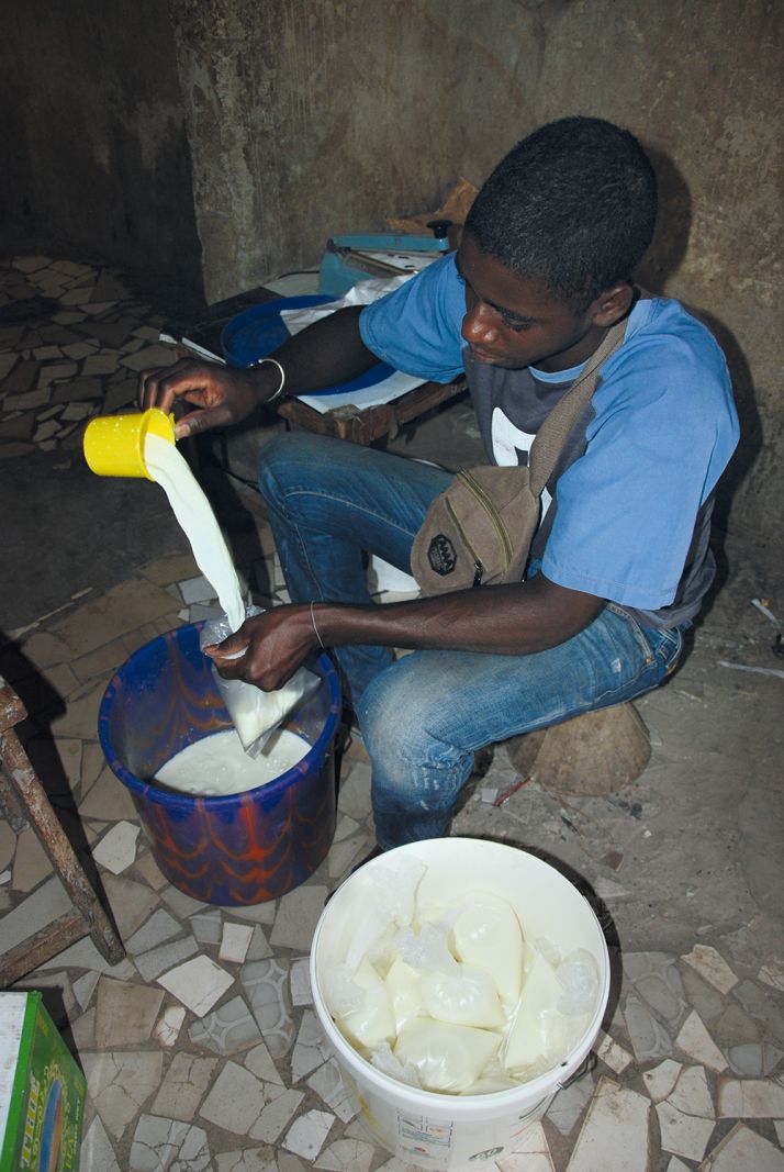 Thierno remplit les sachets de lait chez Saïdou.