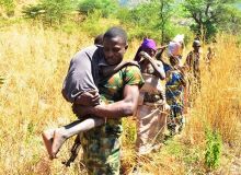 Des paysannes fuient leurs terres, aidées par des militaires, au nord du pays. Photo : Daouda Aliyou