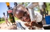 Une fillette au Zimbabwe boit de l'eau propre et salubre un puits réhabilité avec le soutien de l'ONU. Photo : Unicef, Karin Schermbrucker